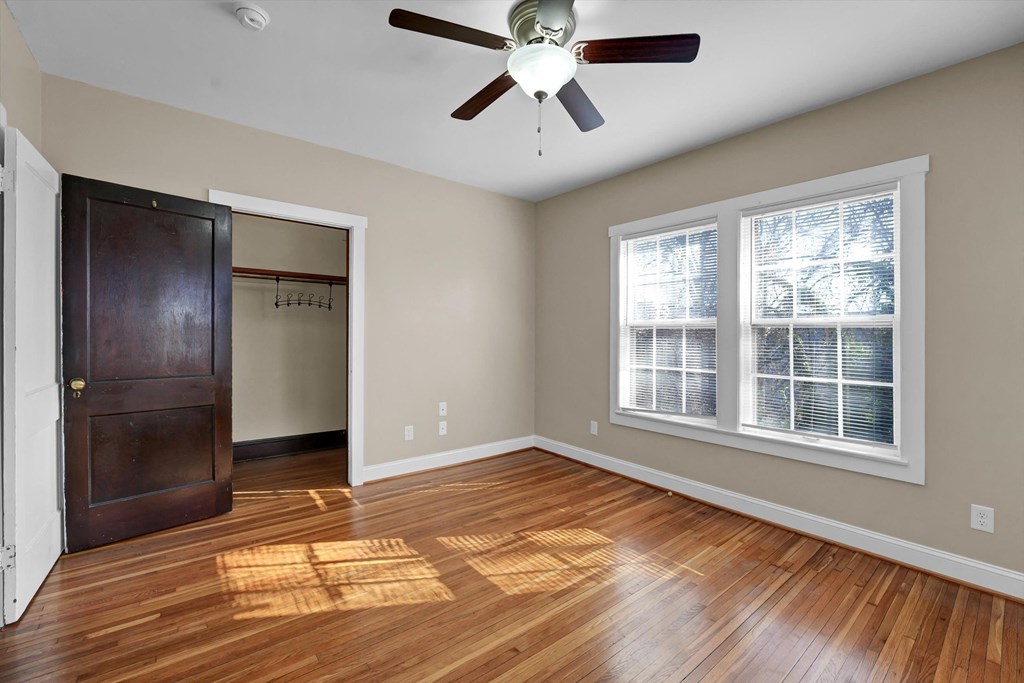 an empty living room with hard wood floors and a ceiling fan