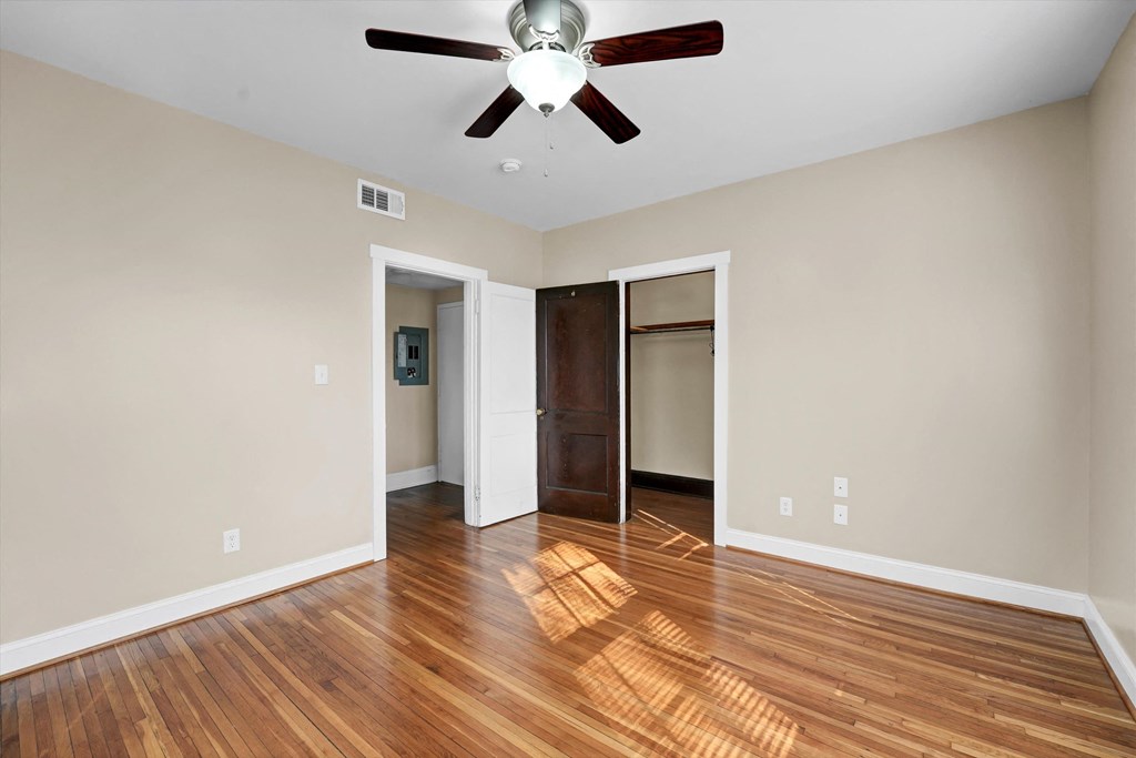 a living room with hard wood floors and a ceiling fan