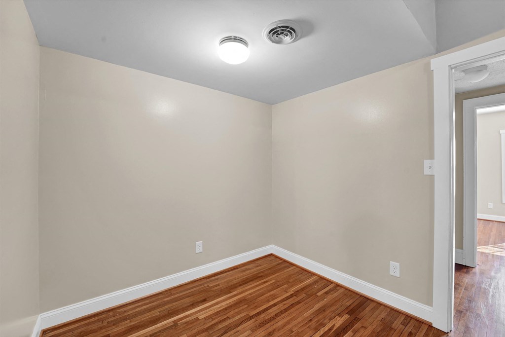an empty living room with wood flooring and white walls