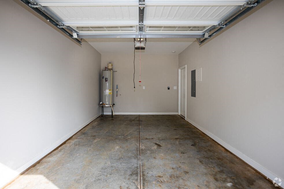 the inside of a garage with a concrete floor and white walls