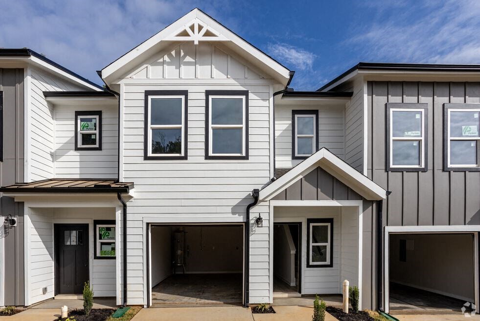 the exterior of a white house with a garage