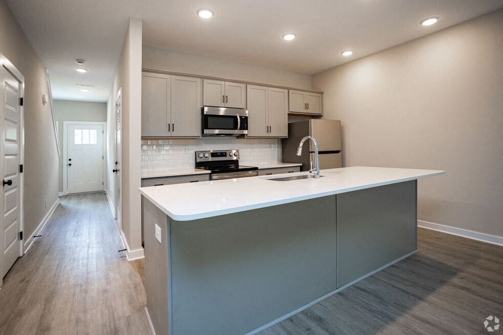 a kitchen with a white counter top and a sink