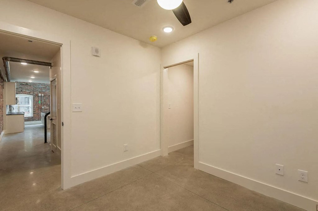a bedroom with a large white wall and a door that leads to a bathroom