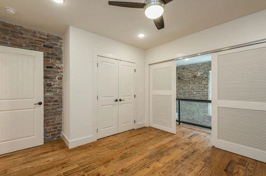 a bedroom with two doors and a brick wall
