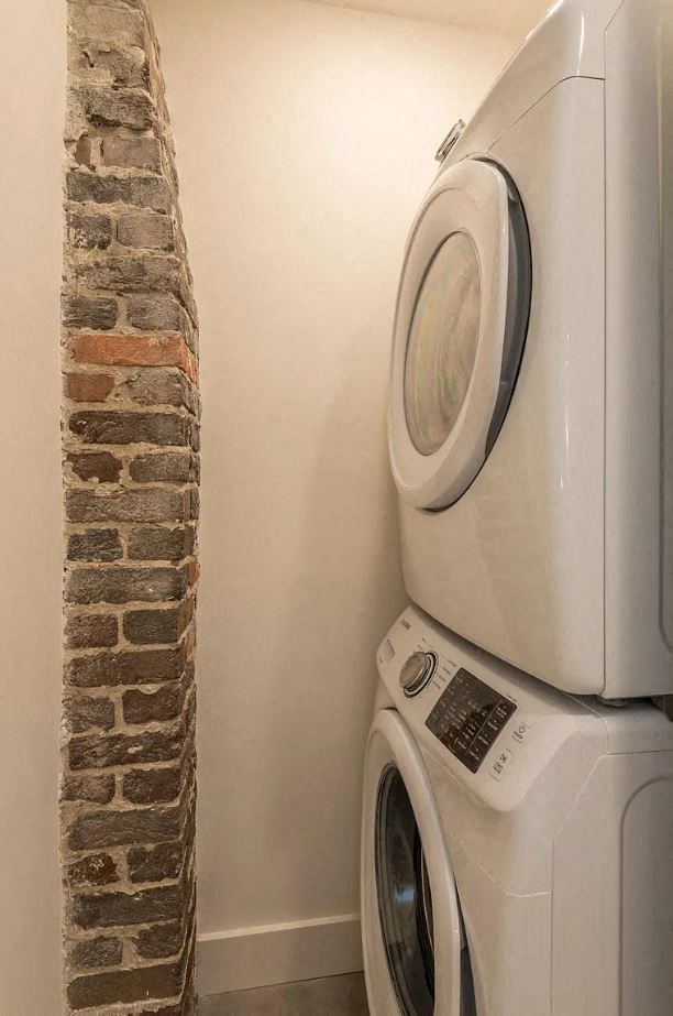 a washer and dryer in a room next to a brick wall