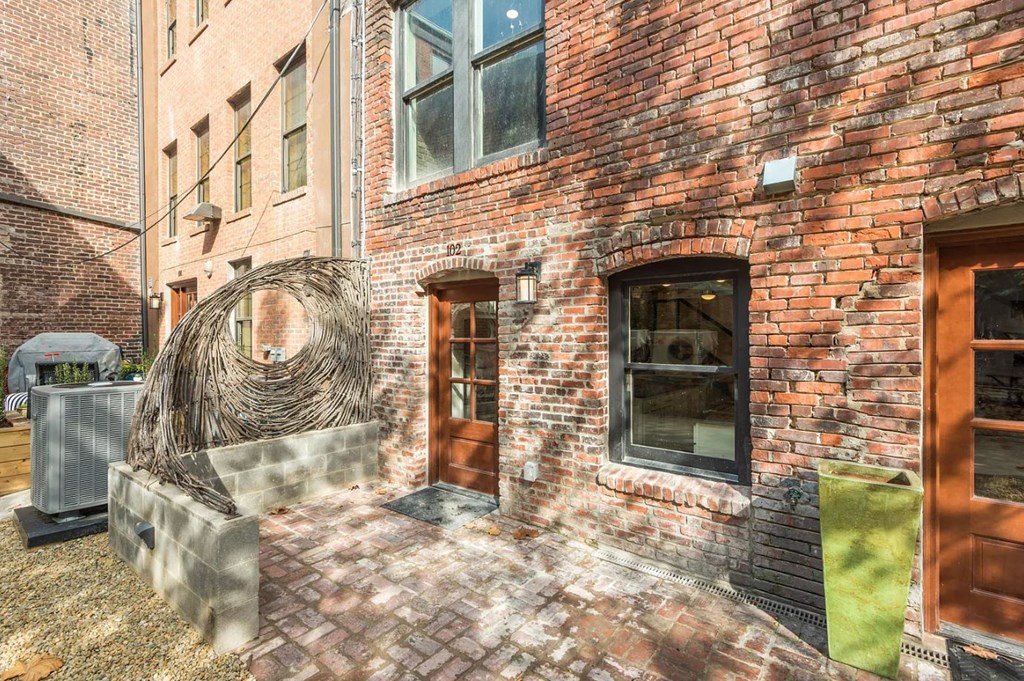 a brick building with a wooden door and a sculpture in front of it