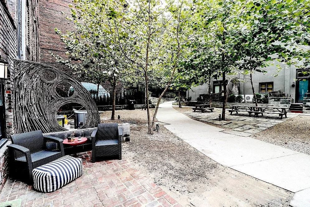 a courtyard with a couch and chairs and trees