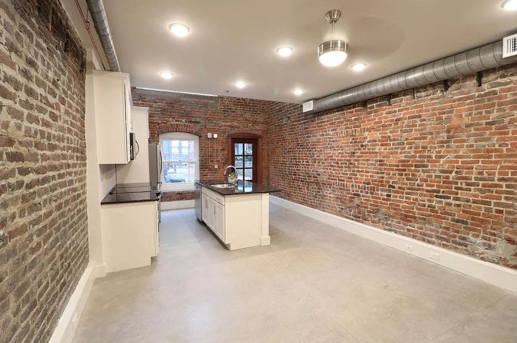 a kitchen with a counter top next to a brick wall