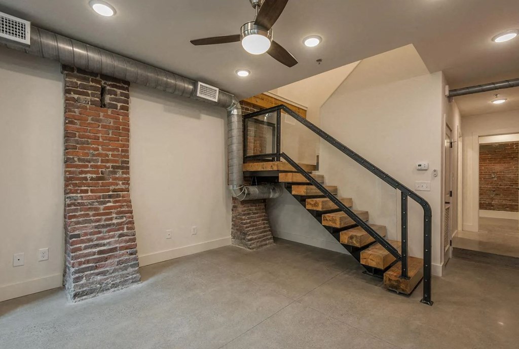 a basement with a staircase and exposed brick walls