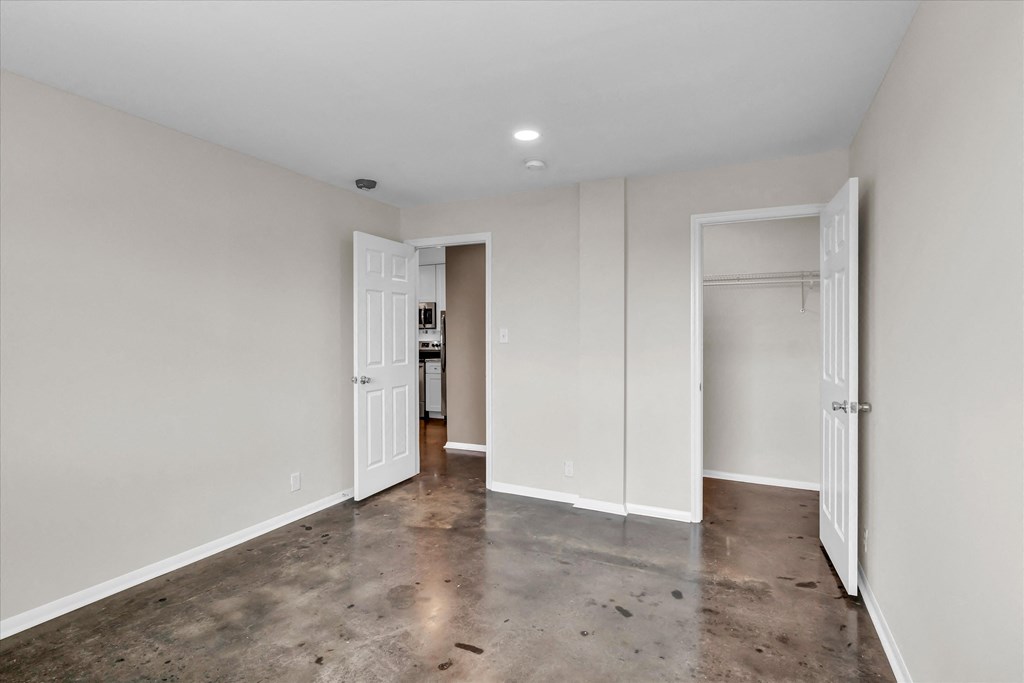 a living room with white walls and a polished concrete floor