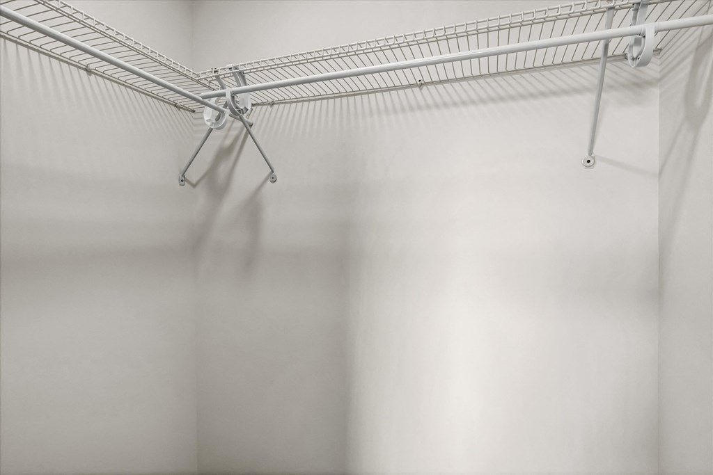 an empty room with a wire rack on the wall
