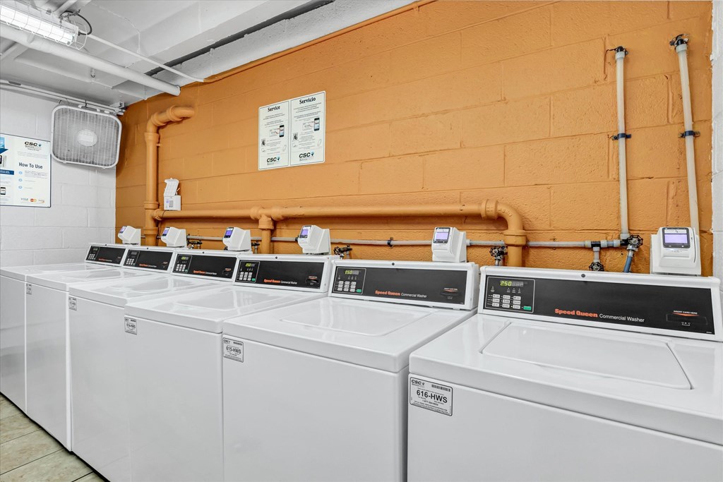 a row of washers and dryers in a laundry room