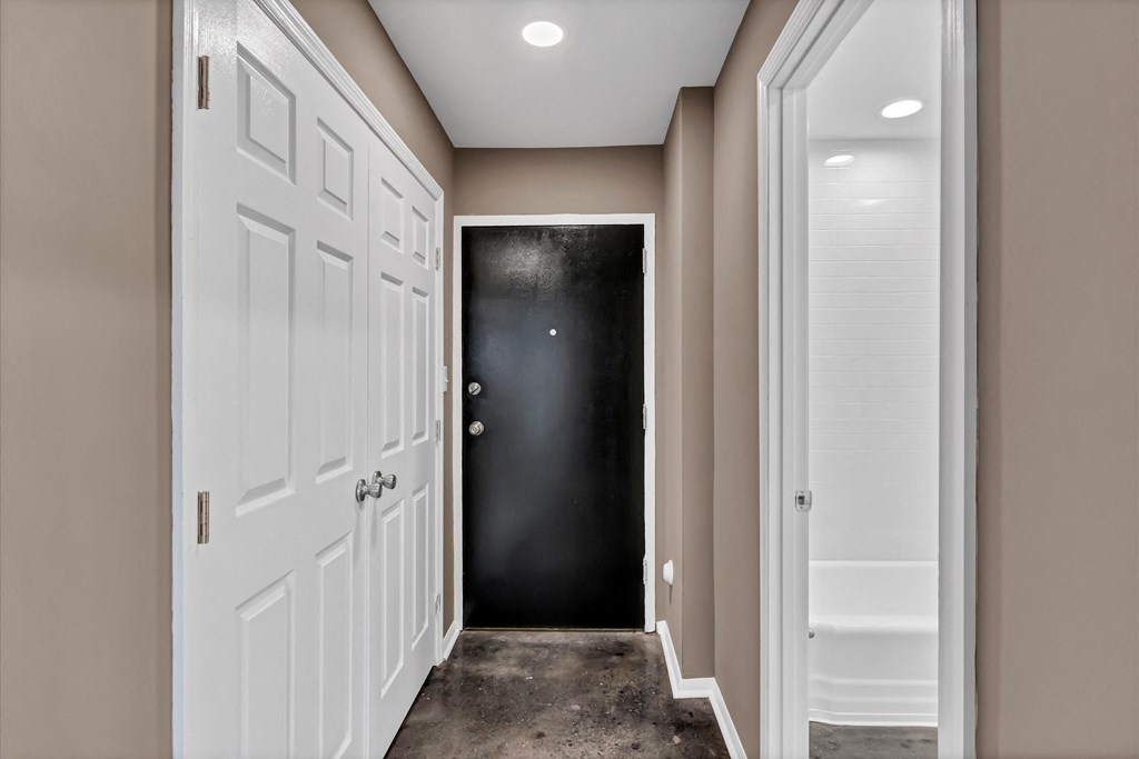 a hallway with white doors and a black door