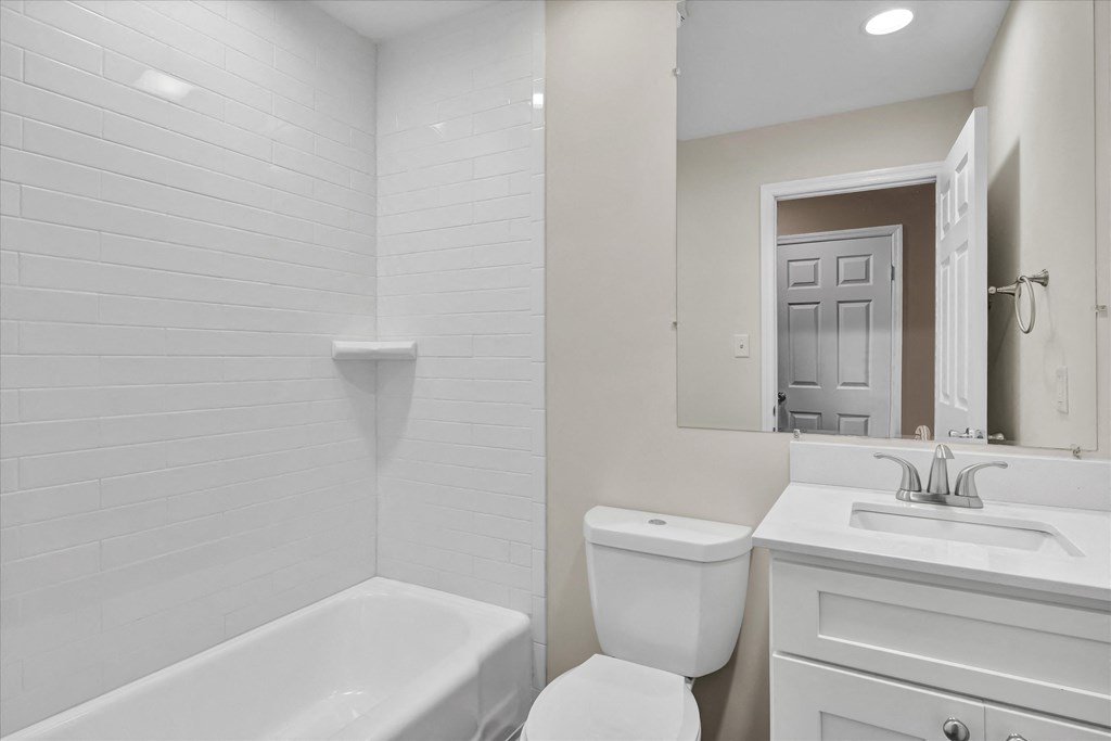 a white bathroom with a toilet and a sink