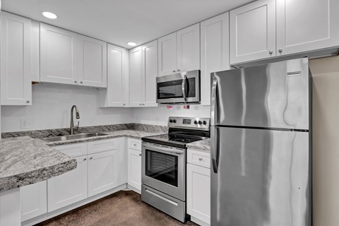 a kitchen with white cabinets and stainless steel appliances
