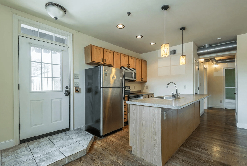 a kitchen with wooden cabinets and a stainless steel refrigerator