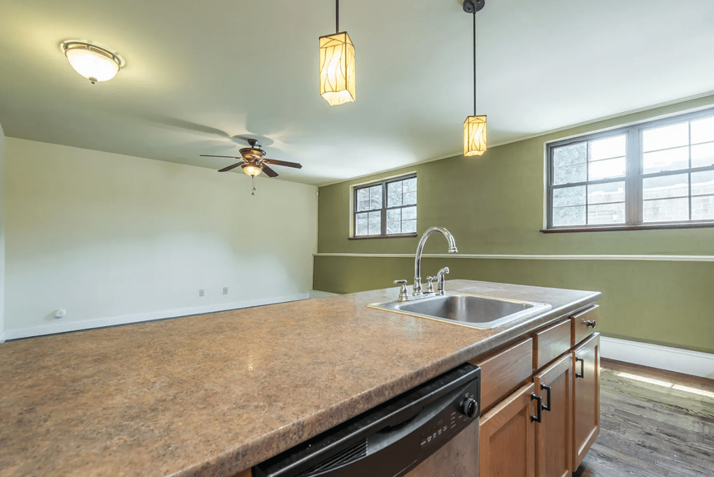 a kitchen with a sink and a ceiling fan