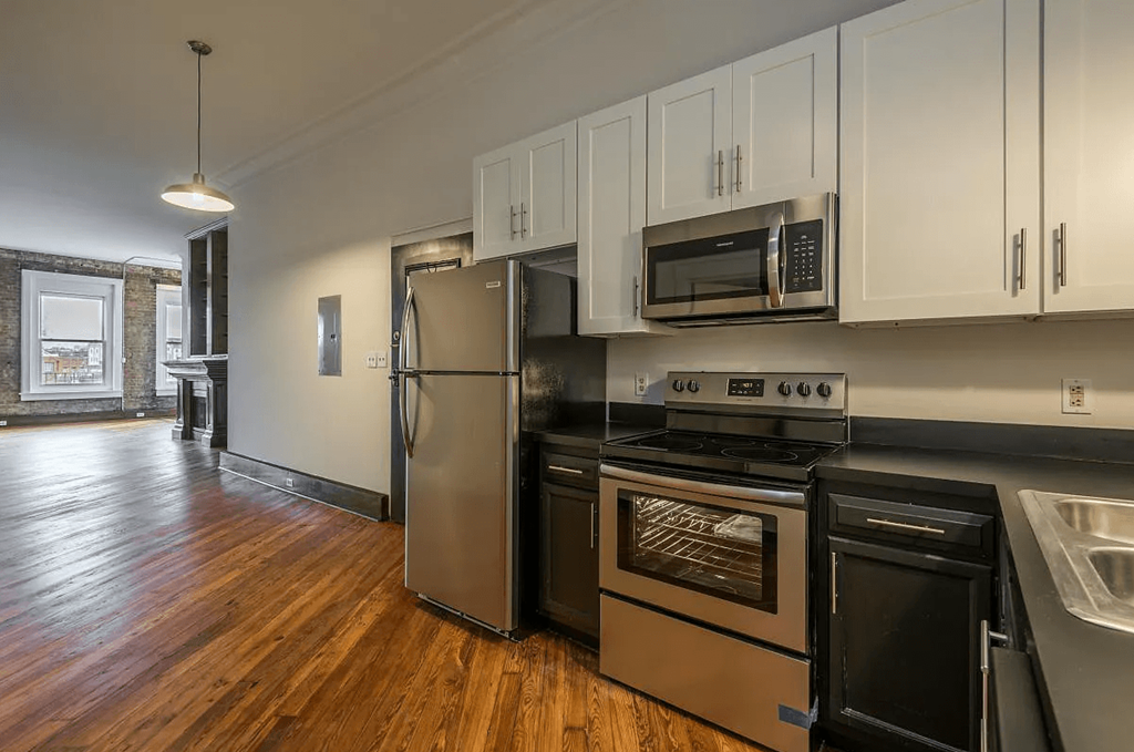 a kitchen with white cabinets and stainless steel appliances