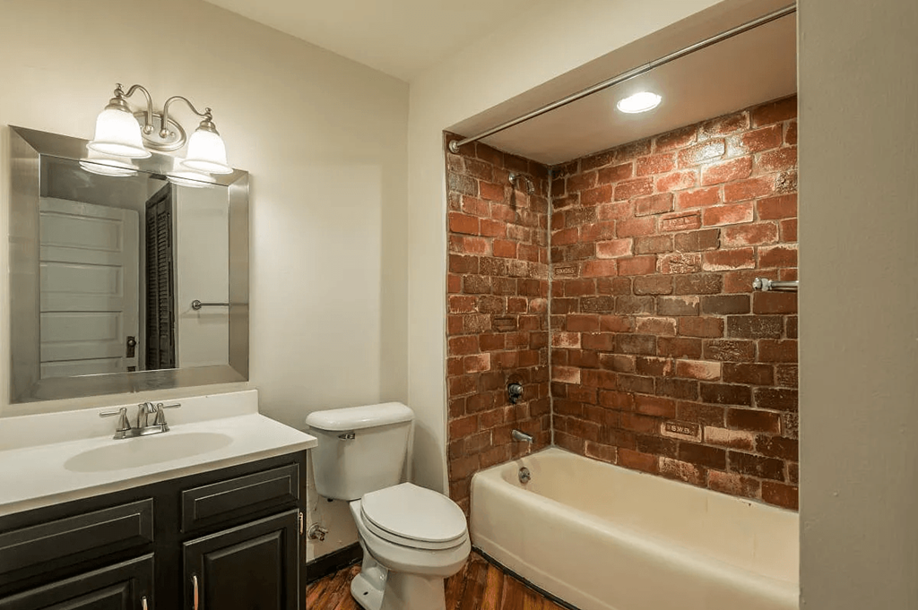 a bathroom with a white toilet next to a bathtub