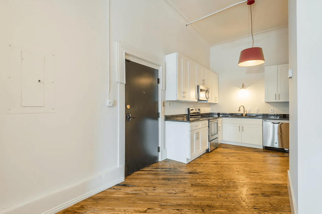 a kitchen with white cabinetry and black countertops