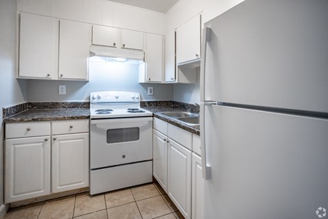 A kitchen with white cabinets and a granite countertop.