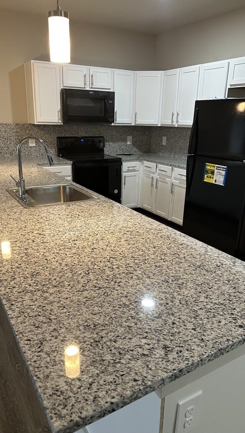 a kitchen with a large granite counter top and a shower
