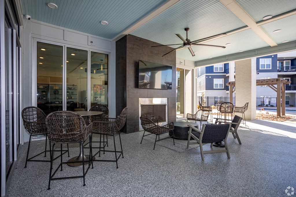 A patio with a fireplace and chairs.