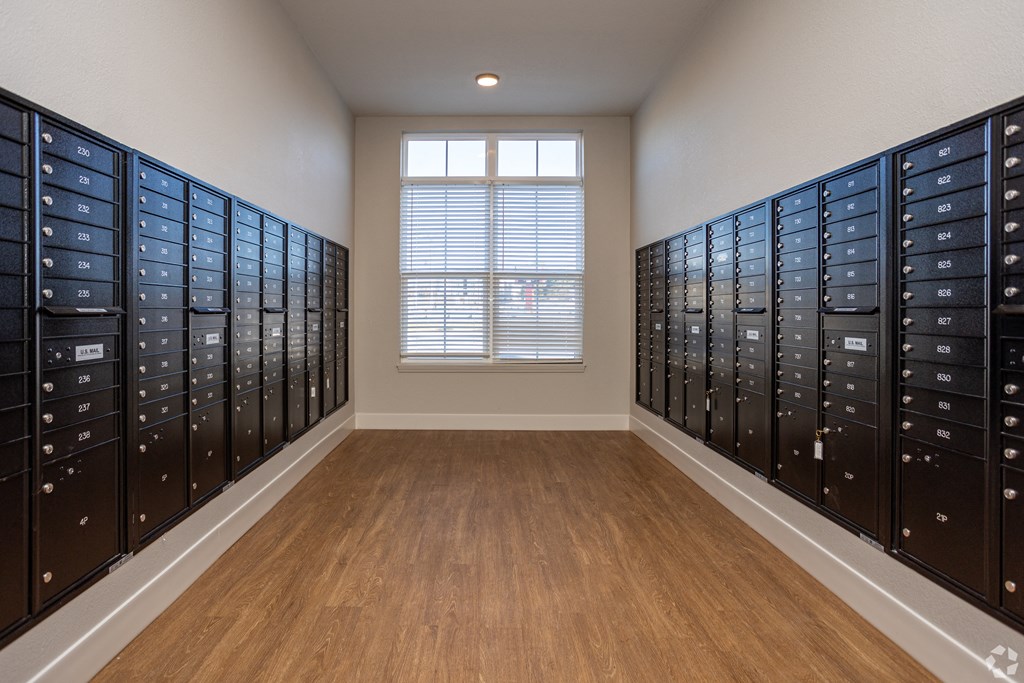 A room with a window and a row of mailboxes on the wall.