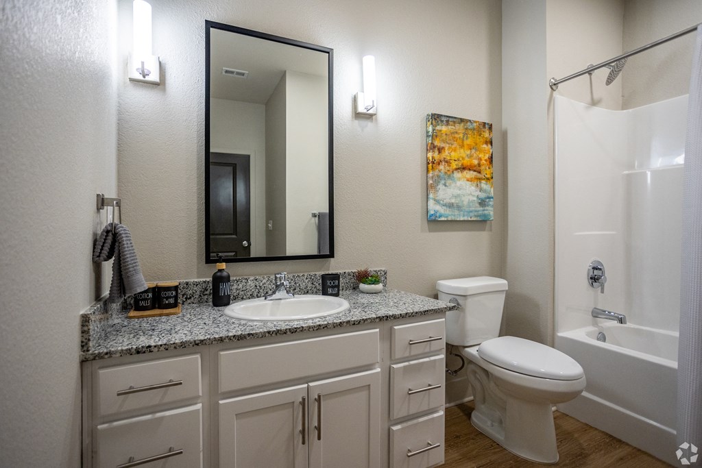 A bathroom with a white toilet, sink, and bathtub.