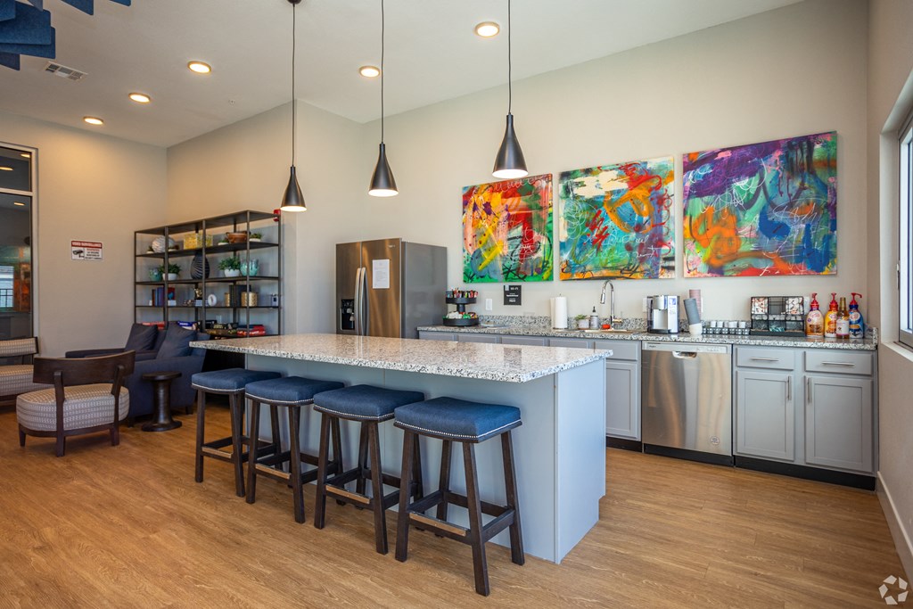 A kitchen with a bar area and a refrigerator.