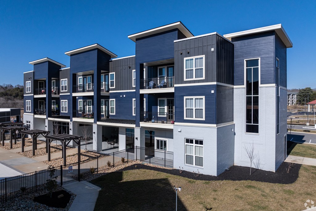 A modern apartment complex with multiple balconies and a mix of blue and grey exterior.