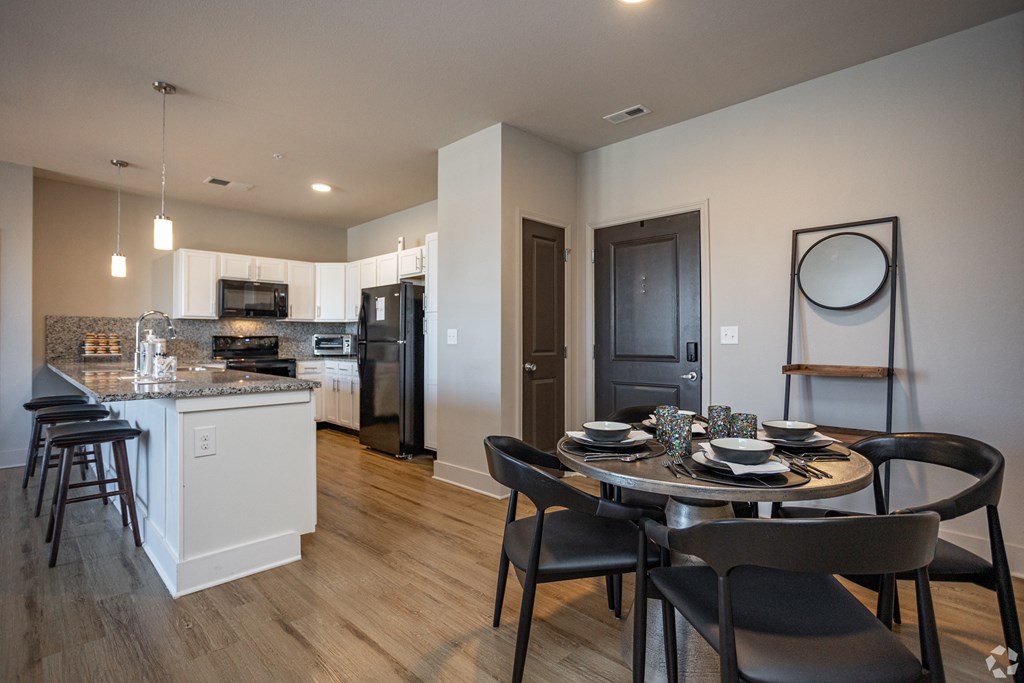 A modern kitchen with a dining table set for four.