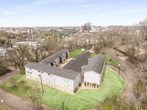 an aerial view of a building with a city in the background