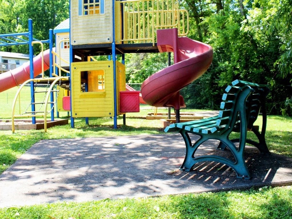 a park bench sitting in front of a playground