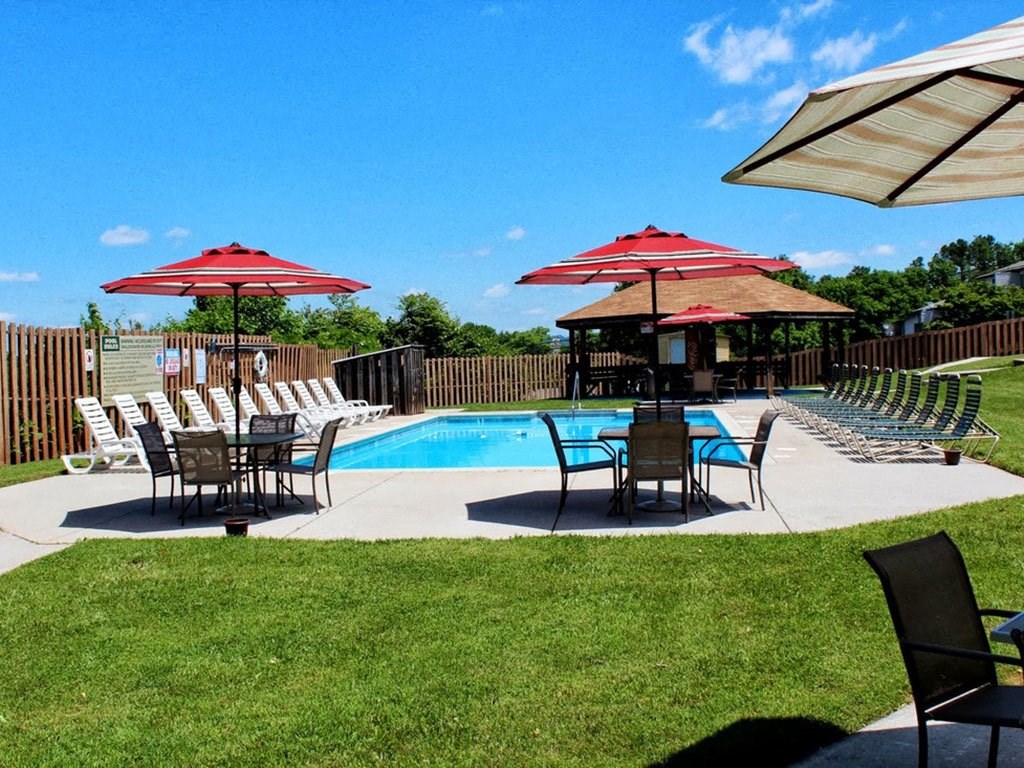 a swimming pool with tables and umbrellas and chairs around it
