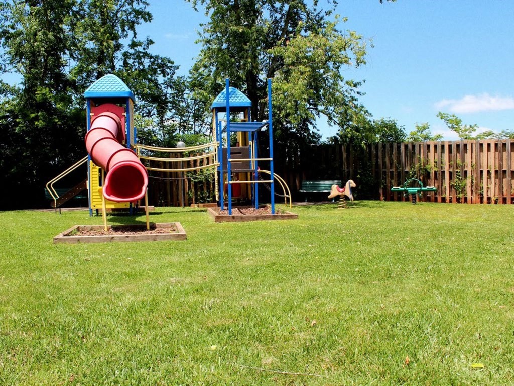 a playground with a slide and other toys in a park