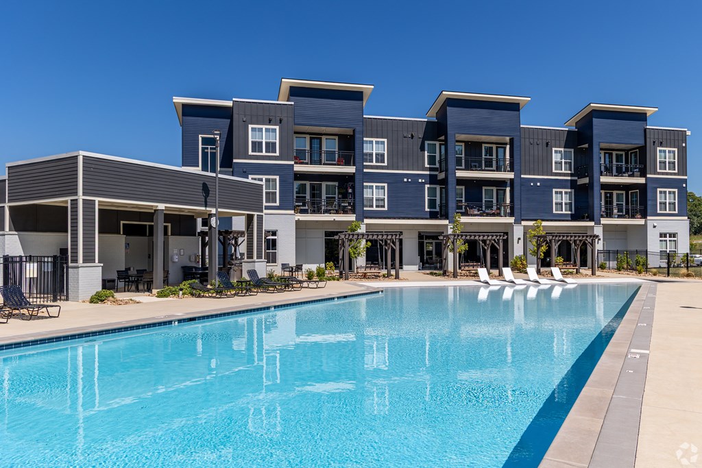 A large swimming pool is in front of a modern building.
