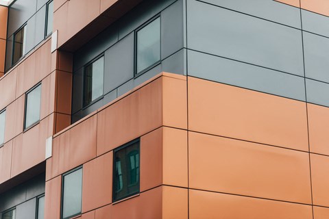 the side of a building with orange facade and windows