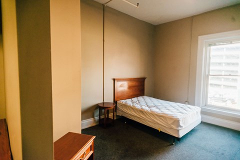 a small bedroom with a bed and a table