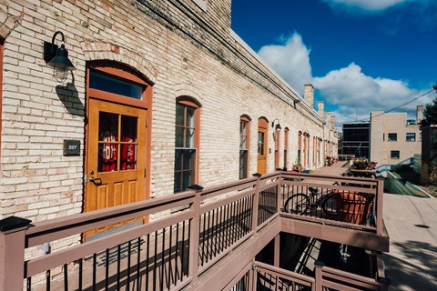 the front porch of a brick building with a wooden door