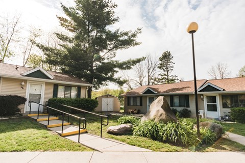 a group of houses with stairs and a tree in the yard