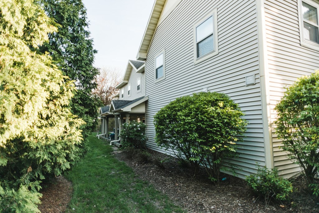 Apartment complex with grey siding and grass