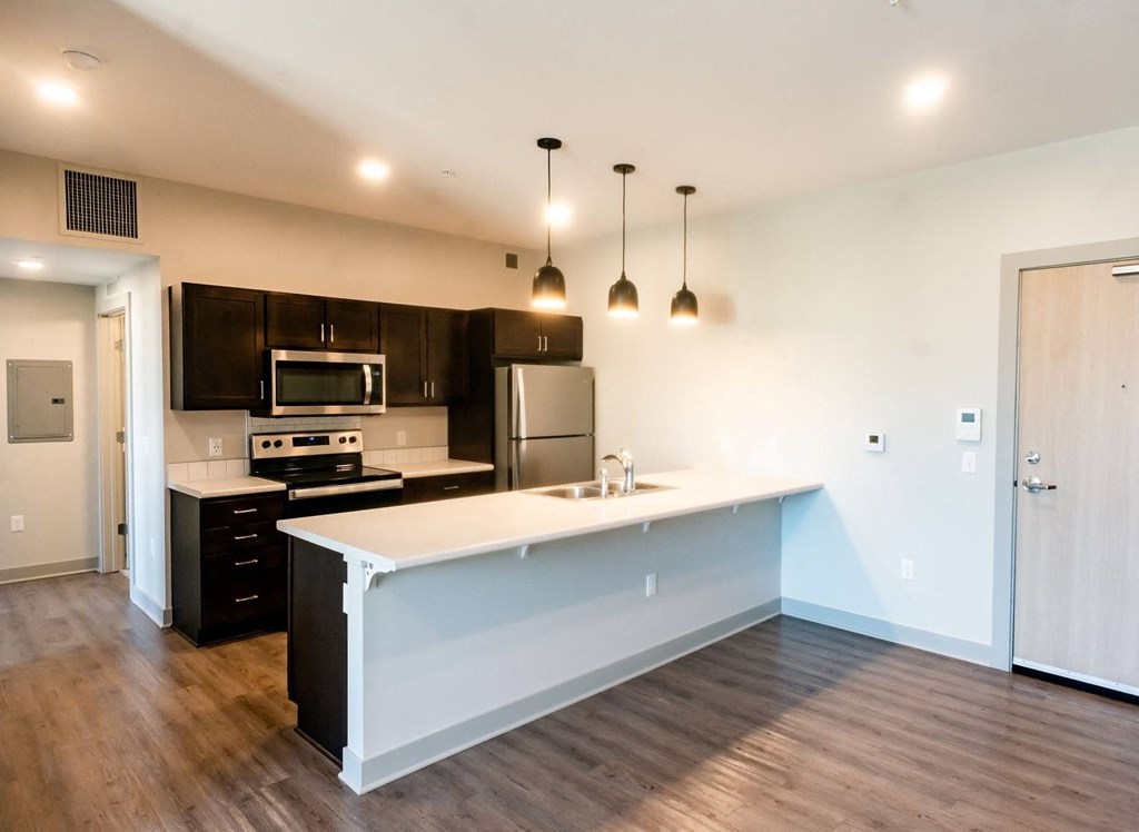 modern kitchen with dark cabinets and light countertops
