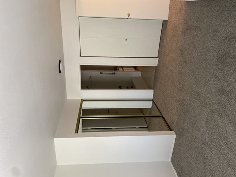 A white cabinet with a drawer is open.