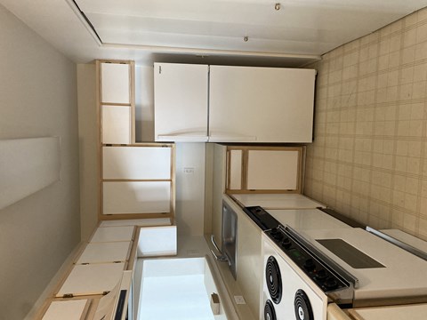 A kitchen with a stove top oven and a refrigerator.