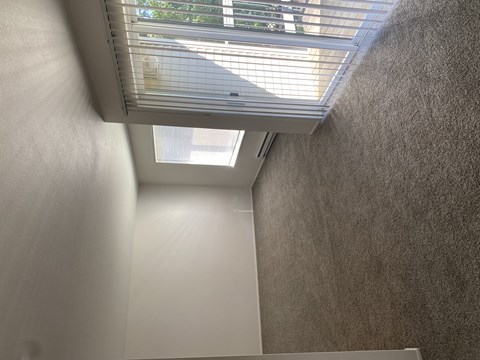 A white wall with a skylight above it.