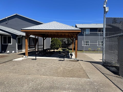 A gazebo is situated in a concrete courtyard.