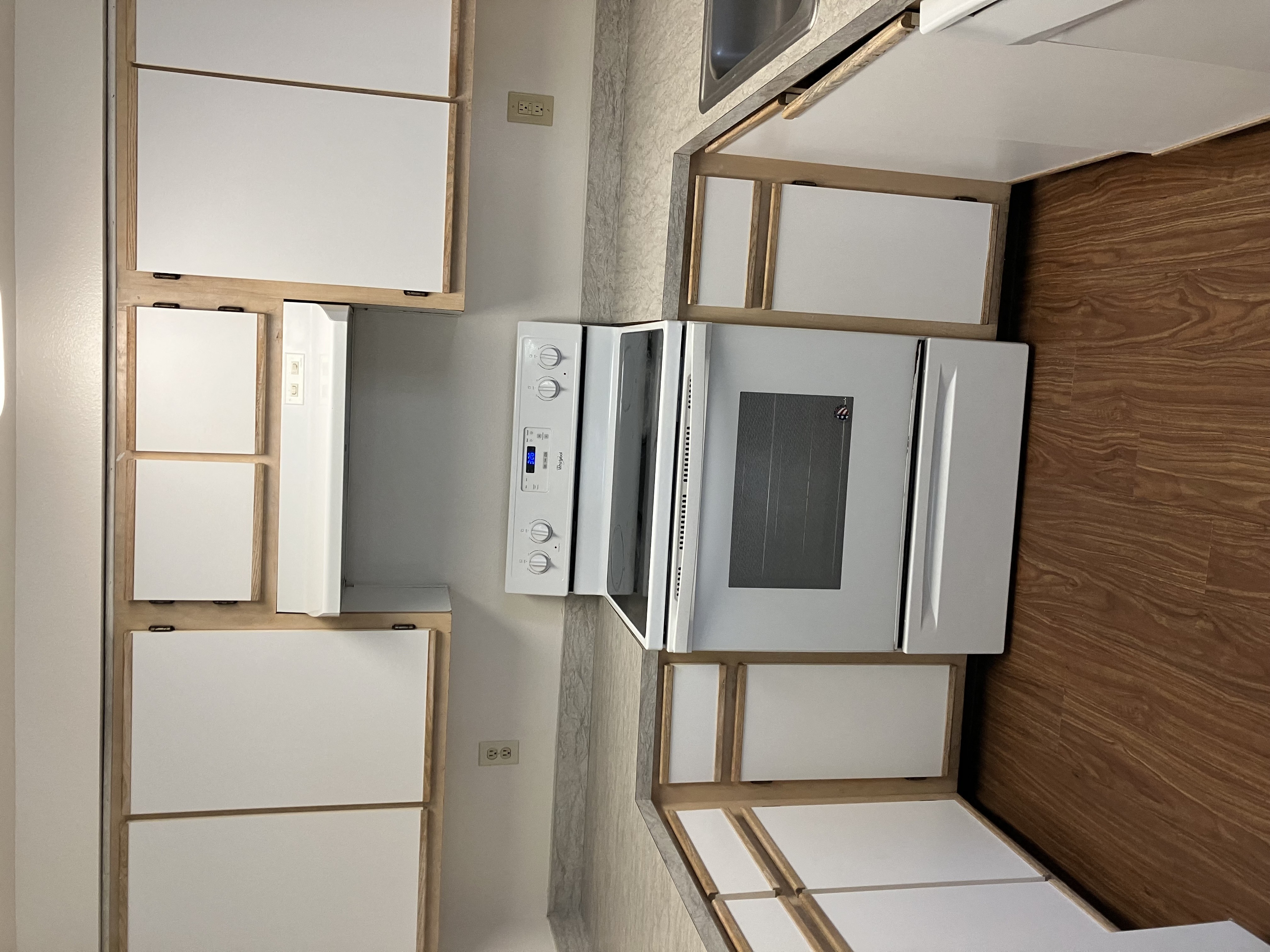 A kitchen with white appliances and wooden cabinets.
