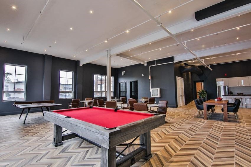 a game room with a pool table and tables