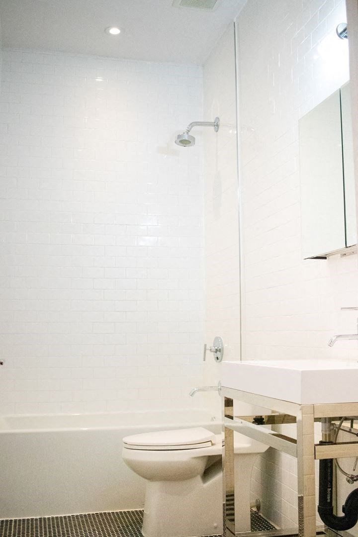 a white bathroom with a toilet and a shower